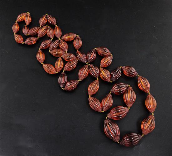 A Chinese amber necklace overall 66in.. sold with a copy of the catalogue